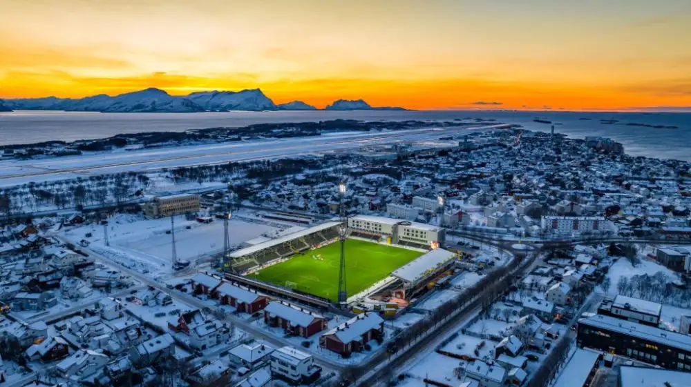 Aspmyra Stadion en invierno, rodeado de nieve y naturaleza ártica en Bodø, Noruega