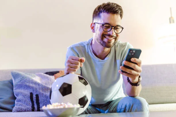 chico haciendo apuestas para el mundial 2026 con un smartphone